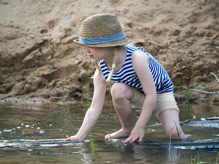 Happy little girl playing in a big puddle of sand quarryの写真素材