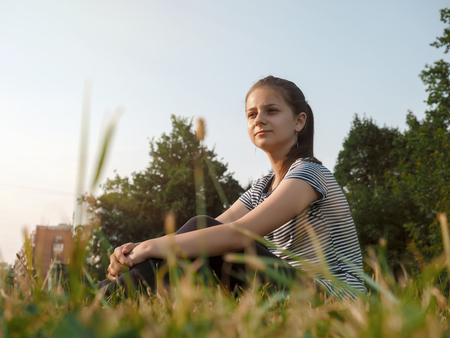 girl sits in Park on the grassの写真素材