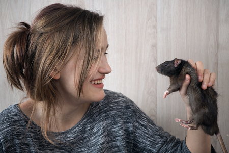The rat and the girl. Emotional portrait, vivid emotions from acquaintance with rodentの写真素材