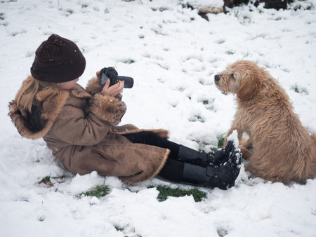 The child takes pictures of the dog. Funny photo shoot of your favorite petの写真素材