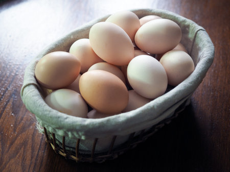 Eggs in wicker basket on a wooden table