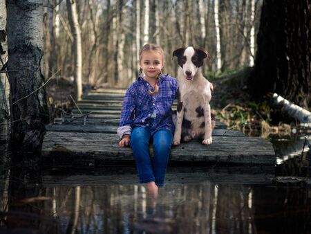 A little girl and a dog to the lake enjoy nature togetherの写真素材