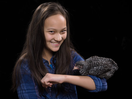 Portrait of a girl with a bird. Black backgroundの写真素材