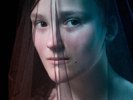 Portrait of a teenage girl under a veil