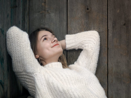 The girl dreams. Portrait of a girl on the background of old boards