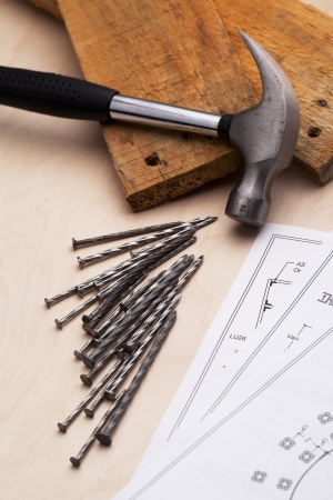 A desk with nails, hammers and blue printsの写真素材