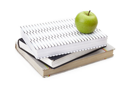 Granny Smith apple sitting on top of a stack of books.の写真素材
