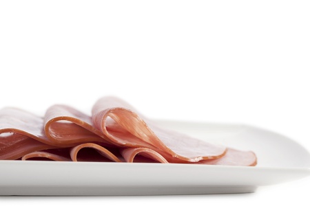 Slices ham on a white plate isolated onの写真素材