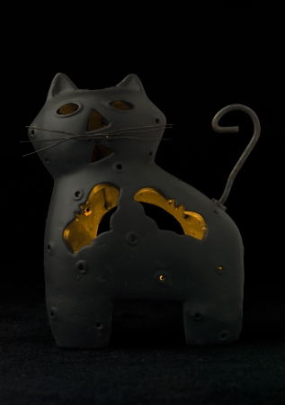 Close-up image of a black cat holder with lighted candle insideの写真素材