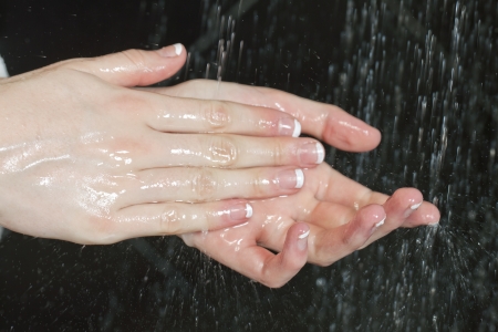 Woman cleaning her hands in front of the showerの写真素材
