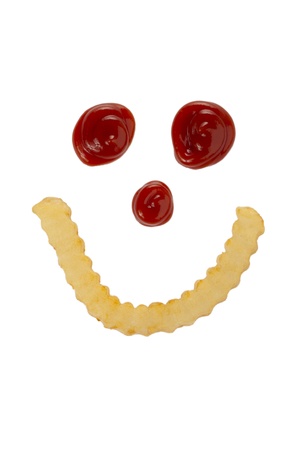 Smiling face made of french fries and ketchup against white backgroundの写真素材