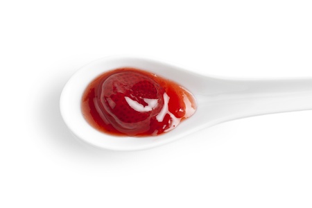 Fresh strawberry jam on a white spoonの写真素材