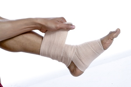 Closed up man putting bandage on his injured feetの写真素材