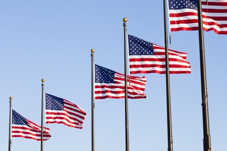A pole of American flag on isolated on a clear blue skyの写真素材