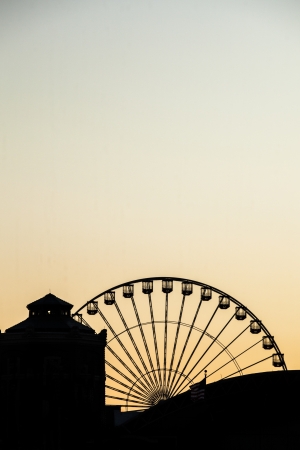 Ferris wheel at sunset in a silhouette imageの写真素材