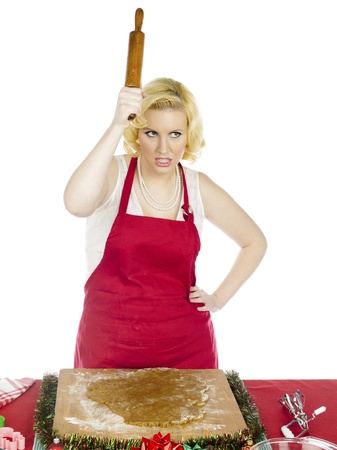 Furious woman holding a rolling pin while making gingerbread cookies,の写真素材