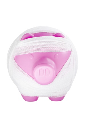Close-up shot of pink damaged piggy bank wrapped in bandage.の写真素材