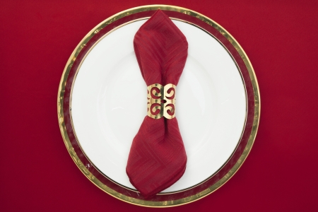 Red sating napkin with napkin ring on a ceramic plateの写真素材