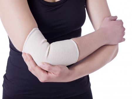 Image of an athlete woman having an elbow pain wrapped with a bandage against the white backgroundの写真素材