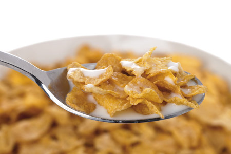 Bowl and spoon with corn flakes and milk