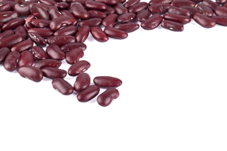 Close-up cropped image of red kidney beans spilled on white surface.