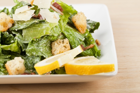 Closed up shot of appetizing plate of caesar salad garnish with lemon slicesの写真素材