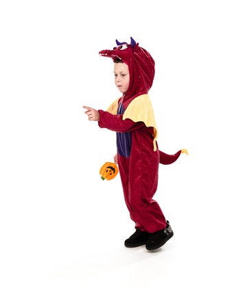 Small kid wearing a costume and holding a candy pointing to direction where he is headed.の写真素材