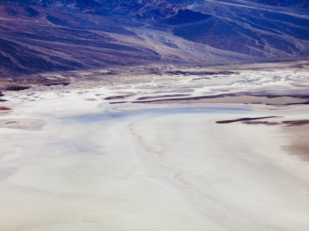 Salt and colorful mountain formations on cratered land.