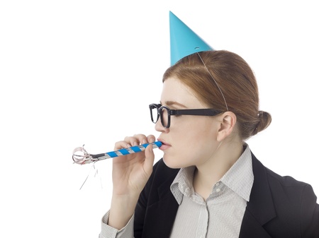 Close-up image of a young businesswoman with party hat and blower whistle celebrating on a white backgroundの写真素材