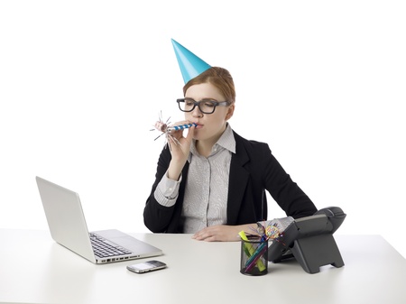 Businesswoman wearing party hat and blowing a party blowerの写真素材