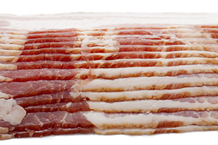 Detailed shot of raw bacon displayed on white background.