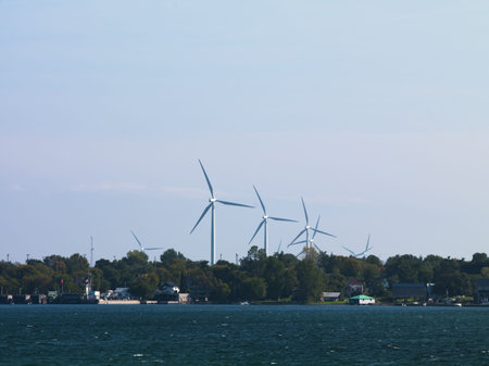 View of wind turbines with river in the foreground.