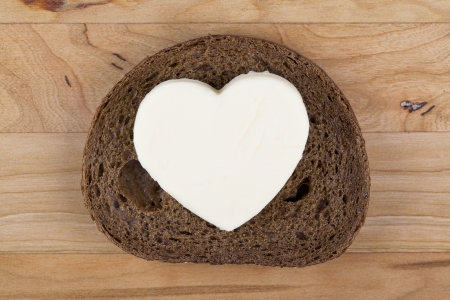 Heart shaped butter on a brown breadの写真素材
