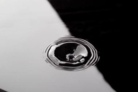 Image of a hole in black water with a waveの写真素材