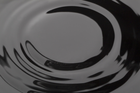 Close-up image of a smooth wave on dark waterの写真素材