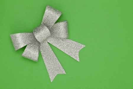 Silver Christmas ribbon lying in green backgroundの写真素材