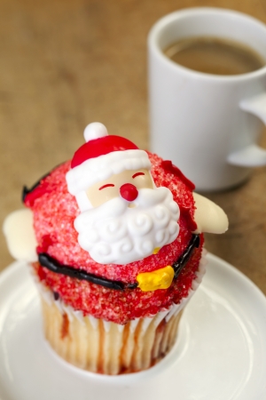 Close-up of decorated christmas cupcake with coffee in backgroundの写真素材