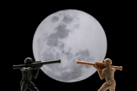 Image of two toy soldier in battle with full moon on the backgroundの写真素材