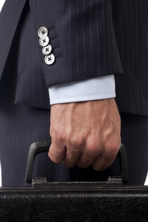 Closed up businessman hand holding a black suitcaseの写真素材