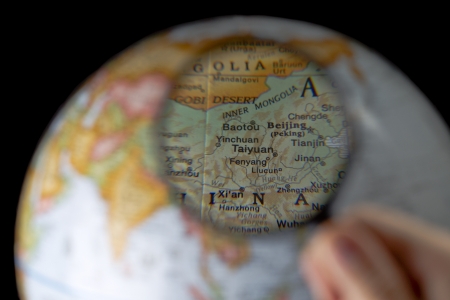 Selective focus image of a globe being magnified using a magnifying glassの写真素材