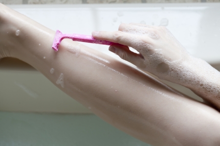 Closed up shot of a female shaving her legsの写真素材
