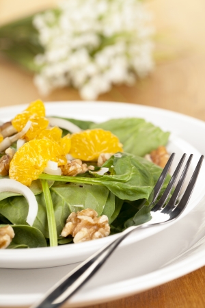 Closed up plate of delicious salad served with fork over a wooden tableの写真素材