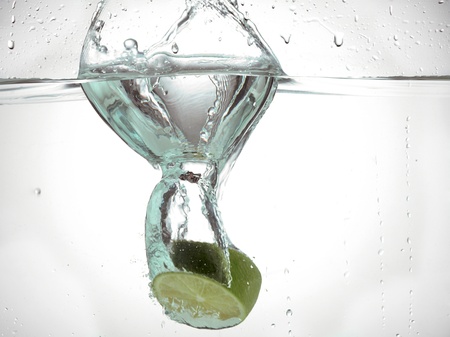 Close-up image of a slice of lime fruit immersed in waterの写真素材