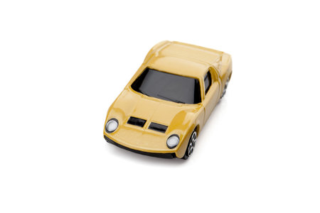 Close-up image of tinted yellow toy car over the white surface