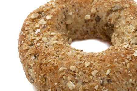 A single whole grain wheat bagel on a white backgroundの写真素材