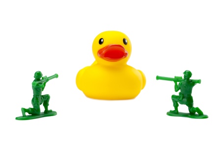 Armed soldiers aiming at a giant rubber duckの写真素材