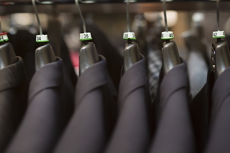 Close-up of business suits hanging in clothing store.の写真素材