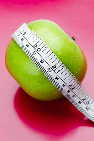 Apple laying its side with a measuring tape around it.の写真素材
