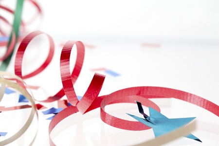 Detailed shot of a shiny red streamer with blue star on white background.の写真素材