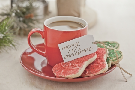 Close-up image of a cup of coffee with holiday tag and cookiesの写真素材